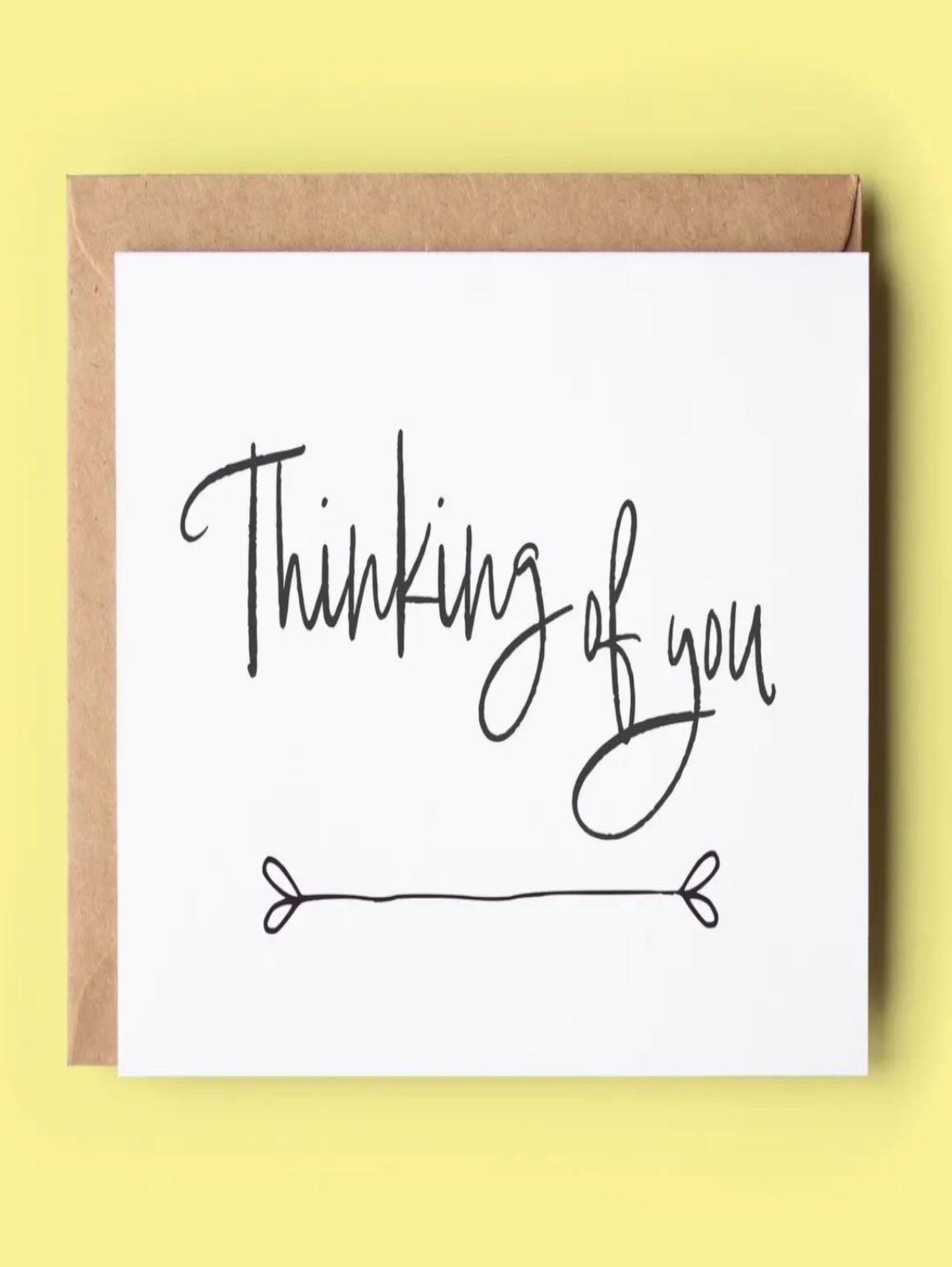 This depicts a white card that has the words thinking of you on it.