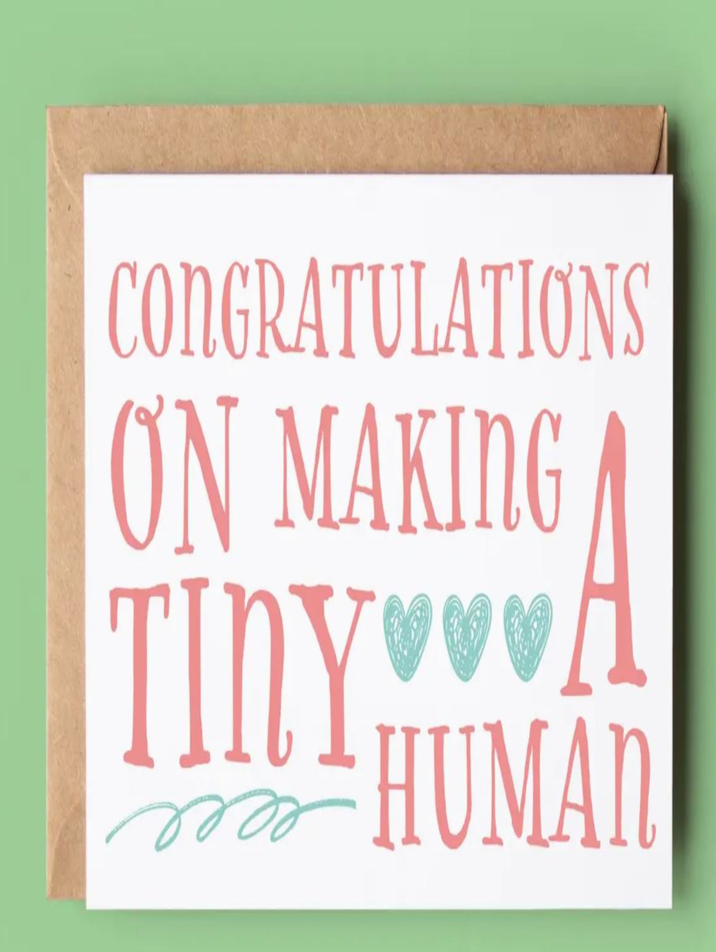 This is a white card that says 'congratulations on making a tiny human' written in red letters.