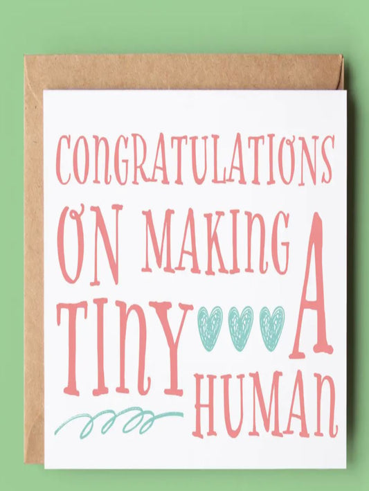 This is a white card that says 'congratulations on making a tiny human' written in red letters.