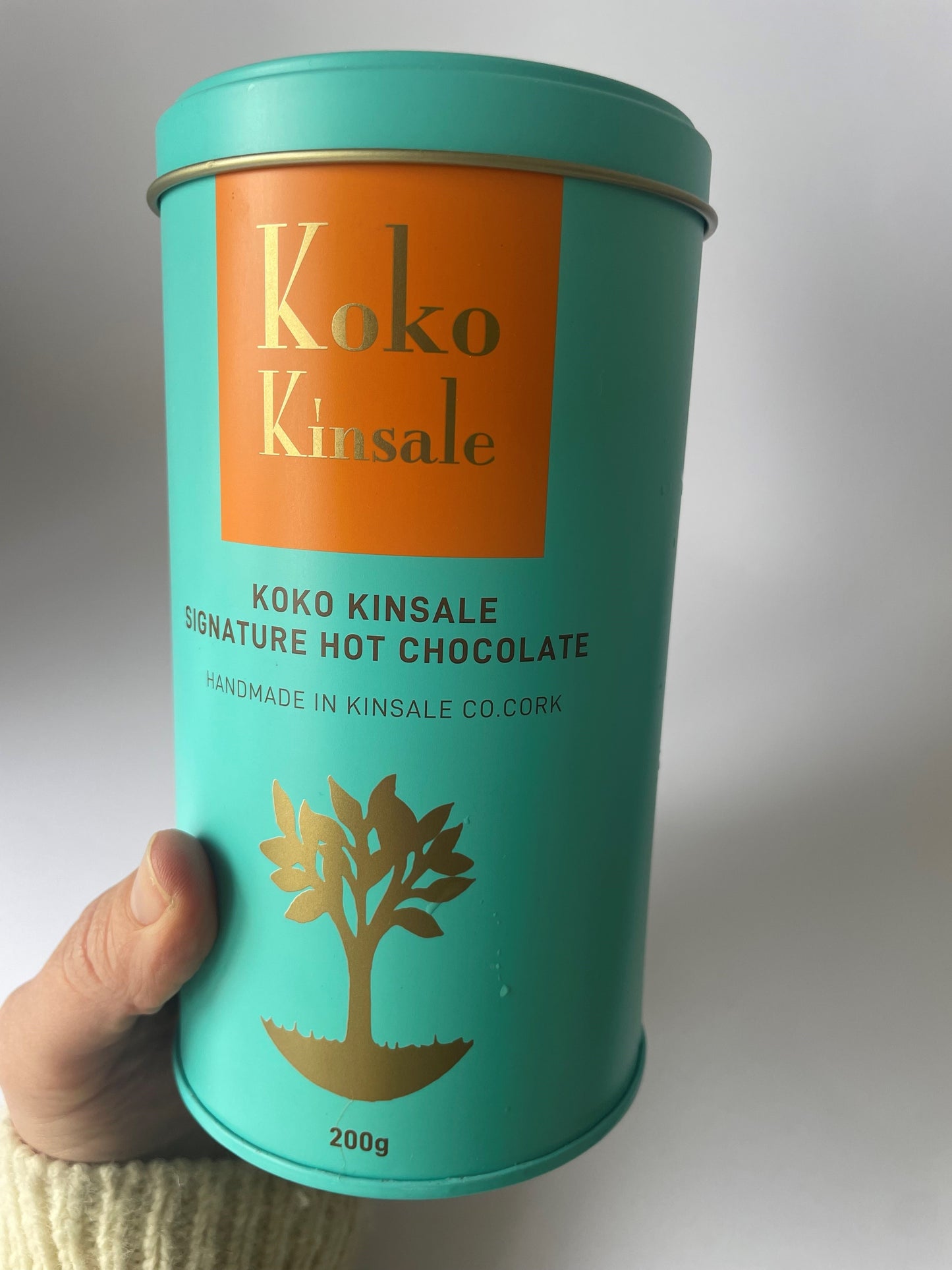 a picture of a hand holding the tin that says Koko Kinsale signature hot chocolate.