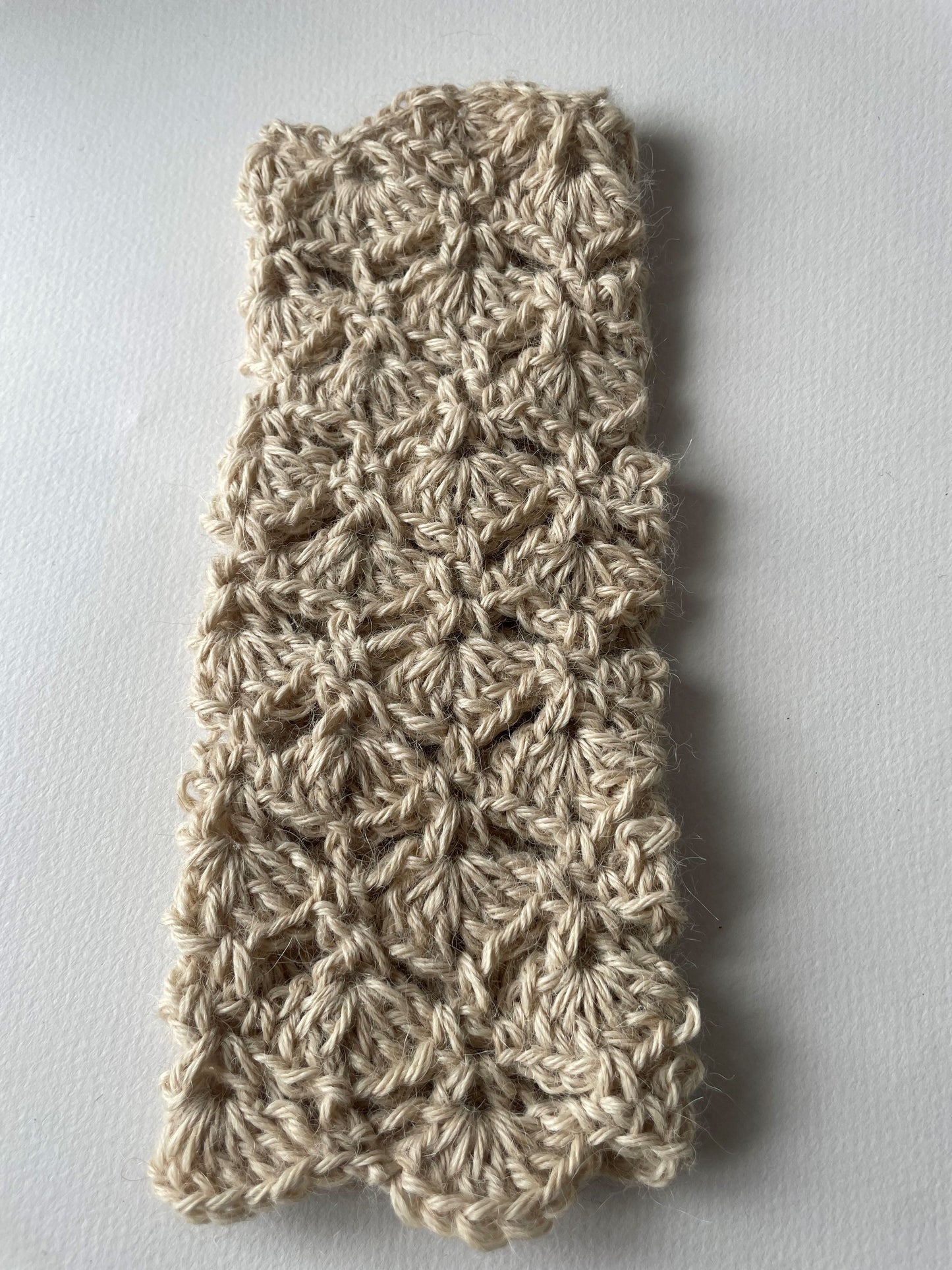 a cream hand knit wristie, this is a fingerless glove.