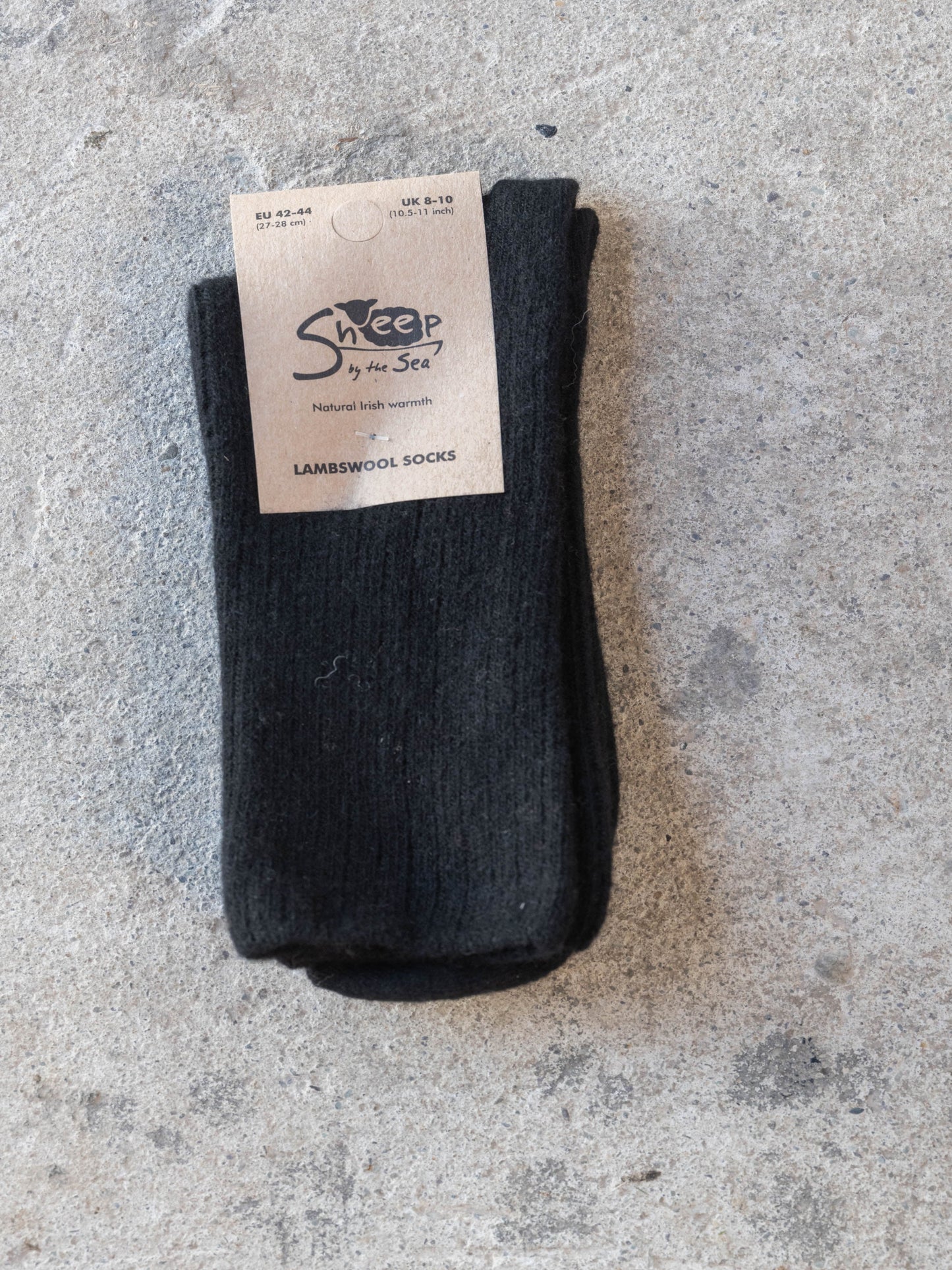 Black sock with a label on a gray concrete surface