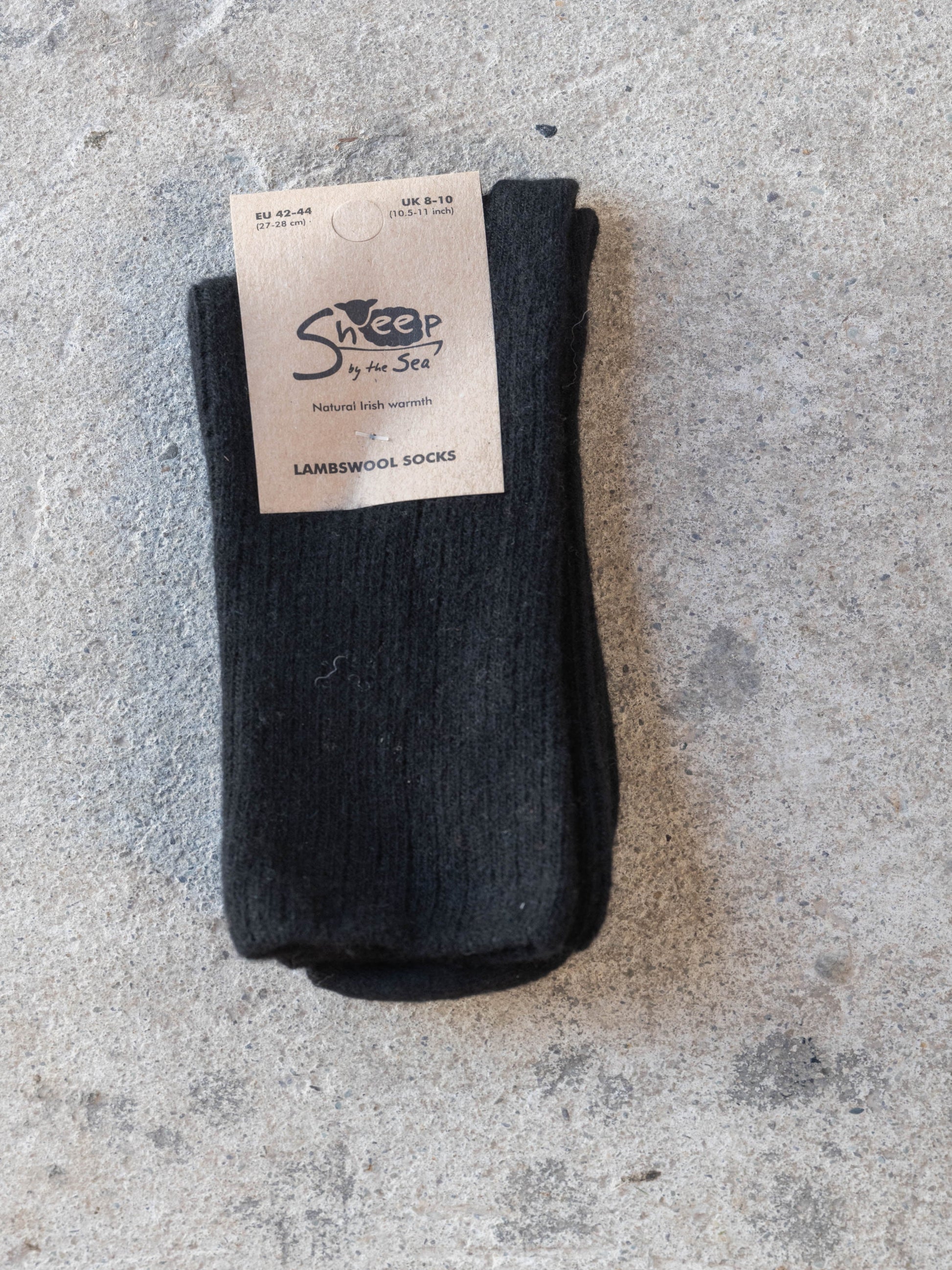 Black sock with a label on a gray concrete surface