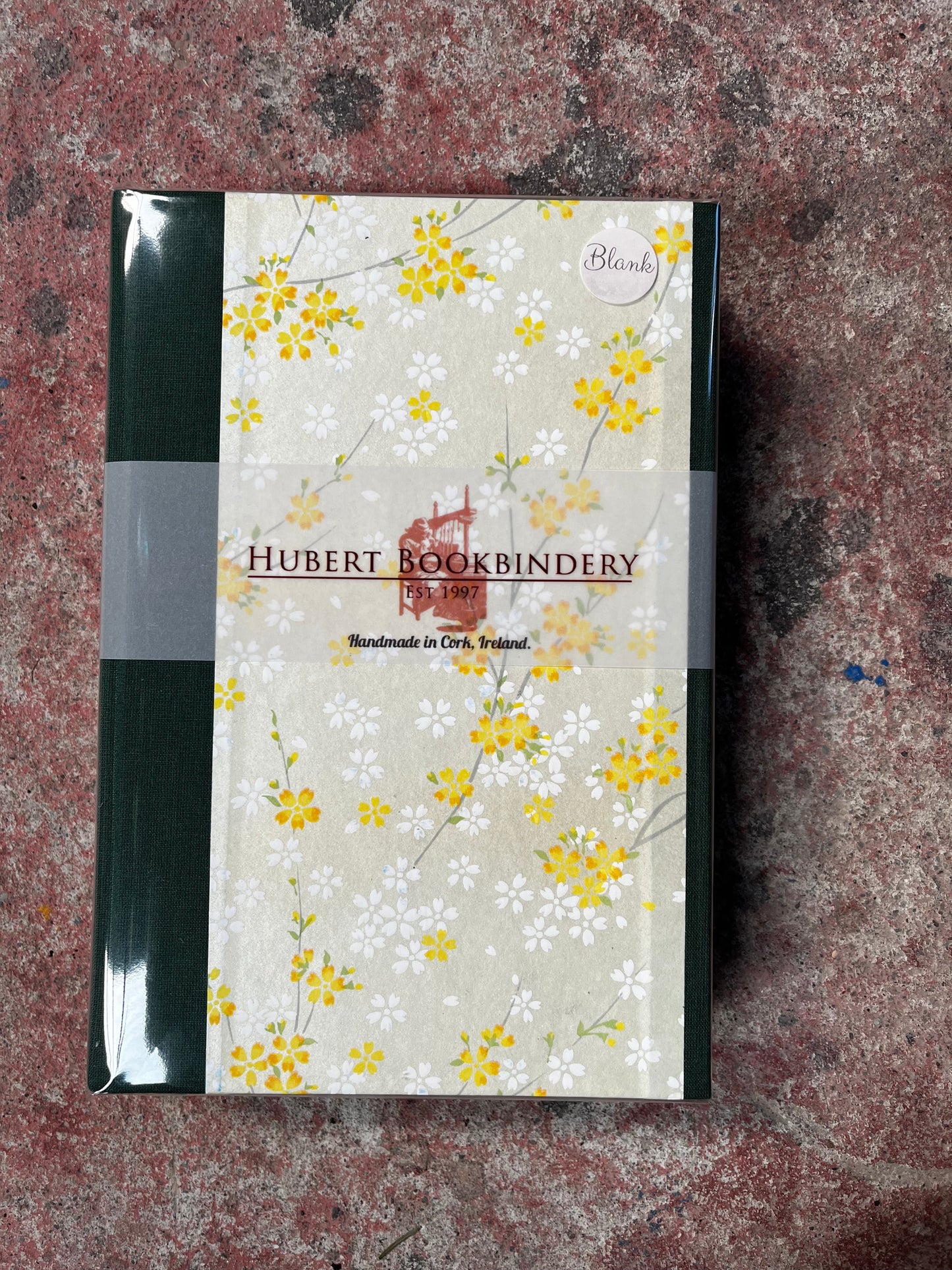 Floral-patterned notebook with 'Hubert Bookbindery' branding on a textured surface
