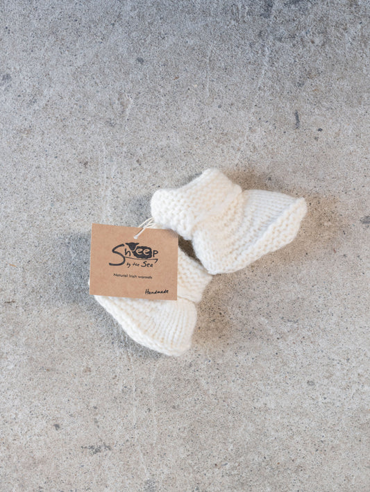 White knitted item on a gray surface with a label