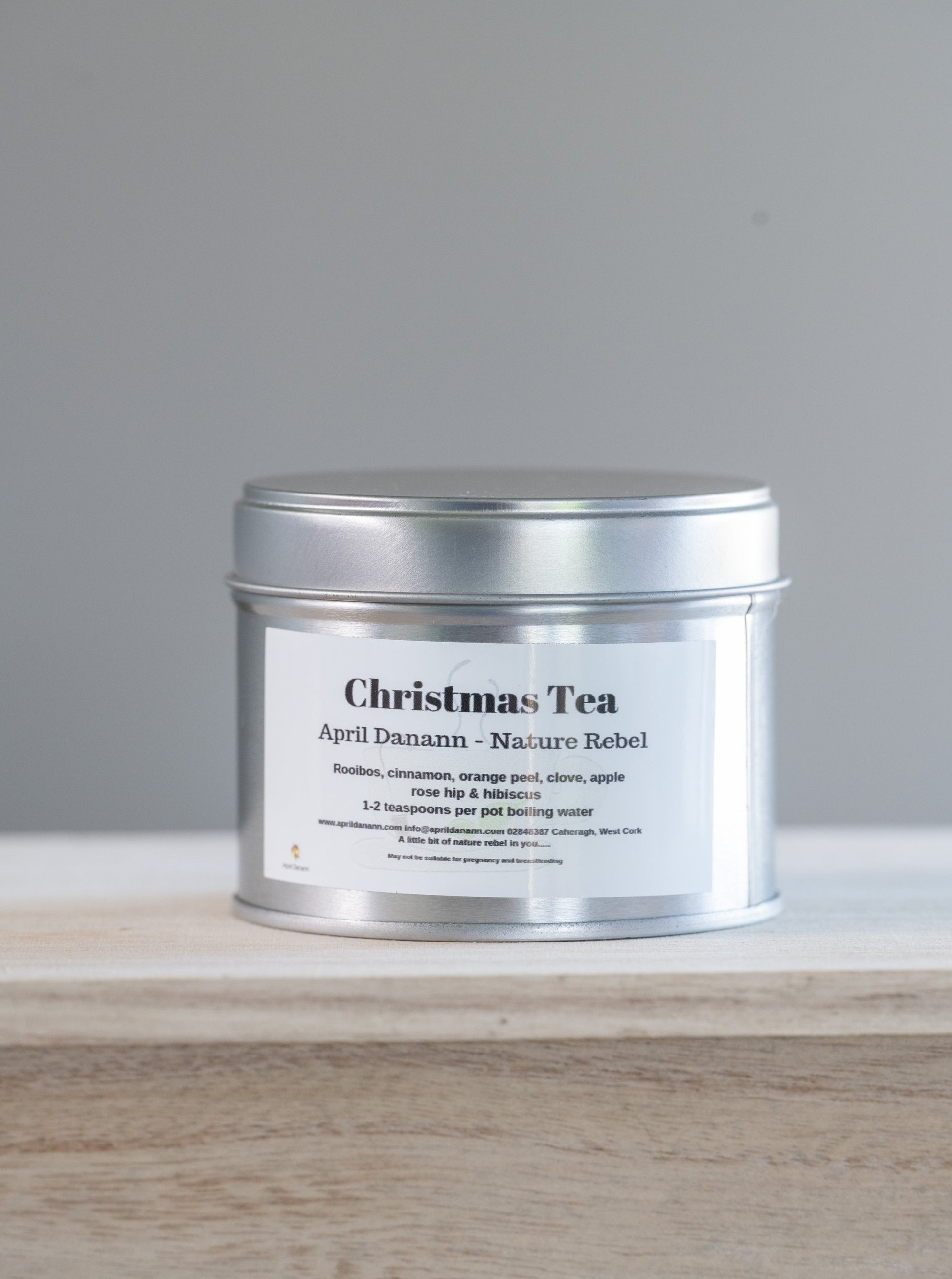 Silver tin of Christmas Tea on a wooden surface with a gray background
