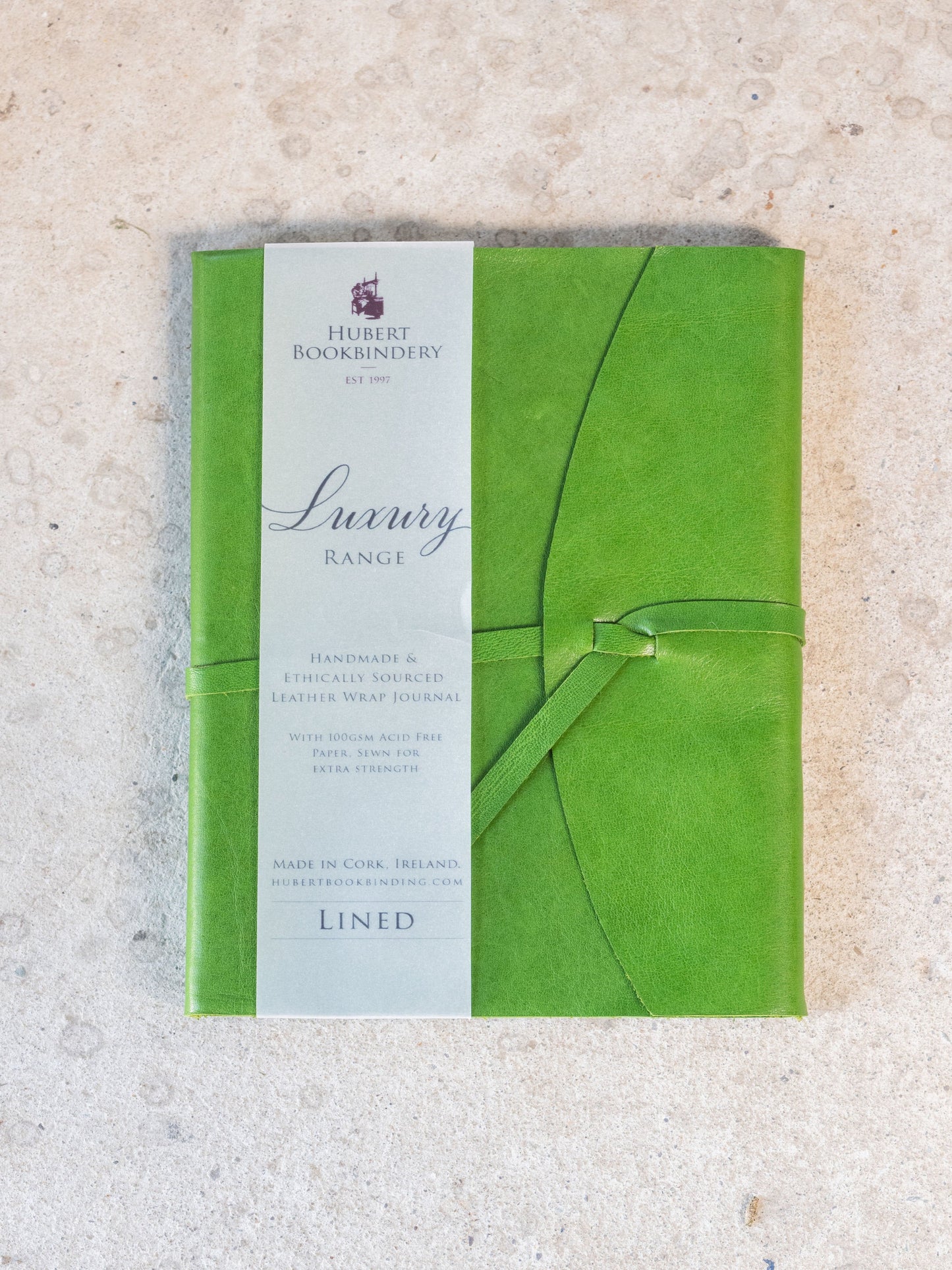 Green book with a label on a textured beige background