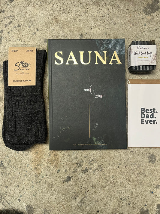 Book titled 'Sauna' with a black sock and a card on a textured surface