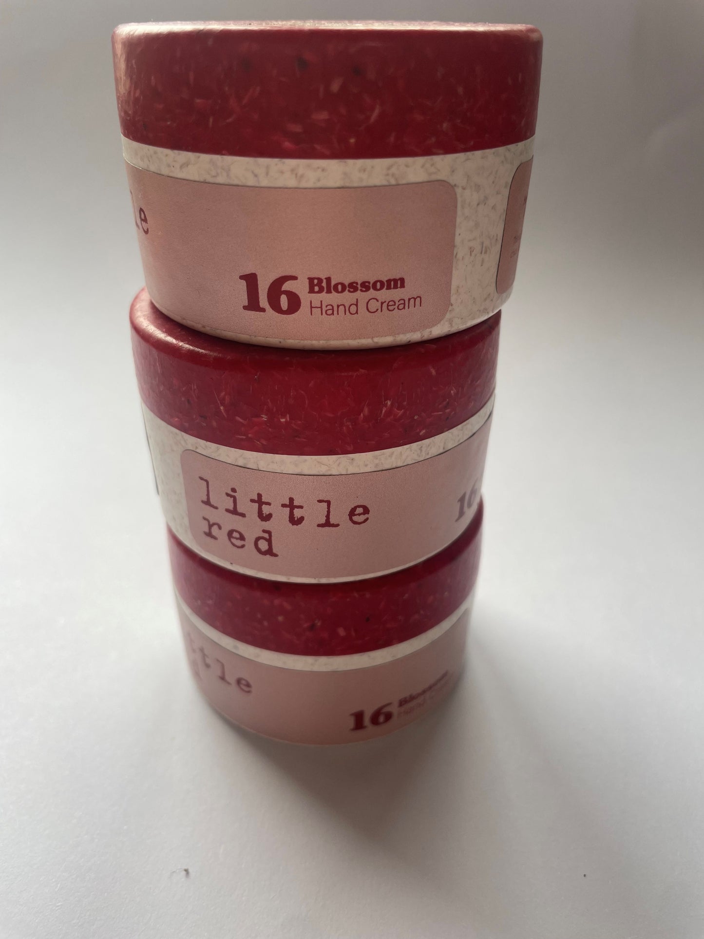 This shows three small jars stacked on top of each other, blossom and cream from little red. 