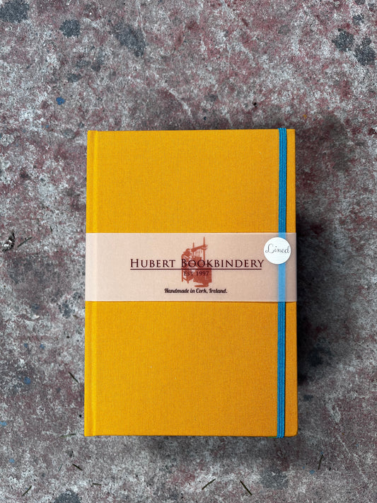 Yellow notebook with a visible brand label on a textured surface
