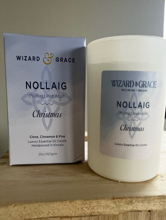 Candle and packaging of Wizard & Grace Nollaig Christmas candle on a wooden surface.