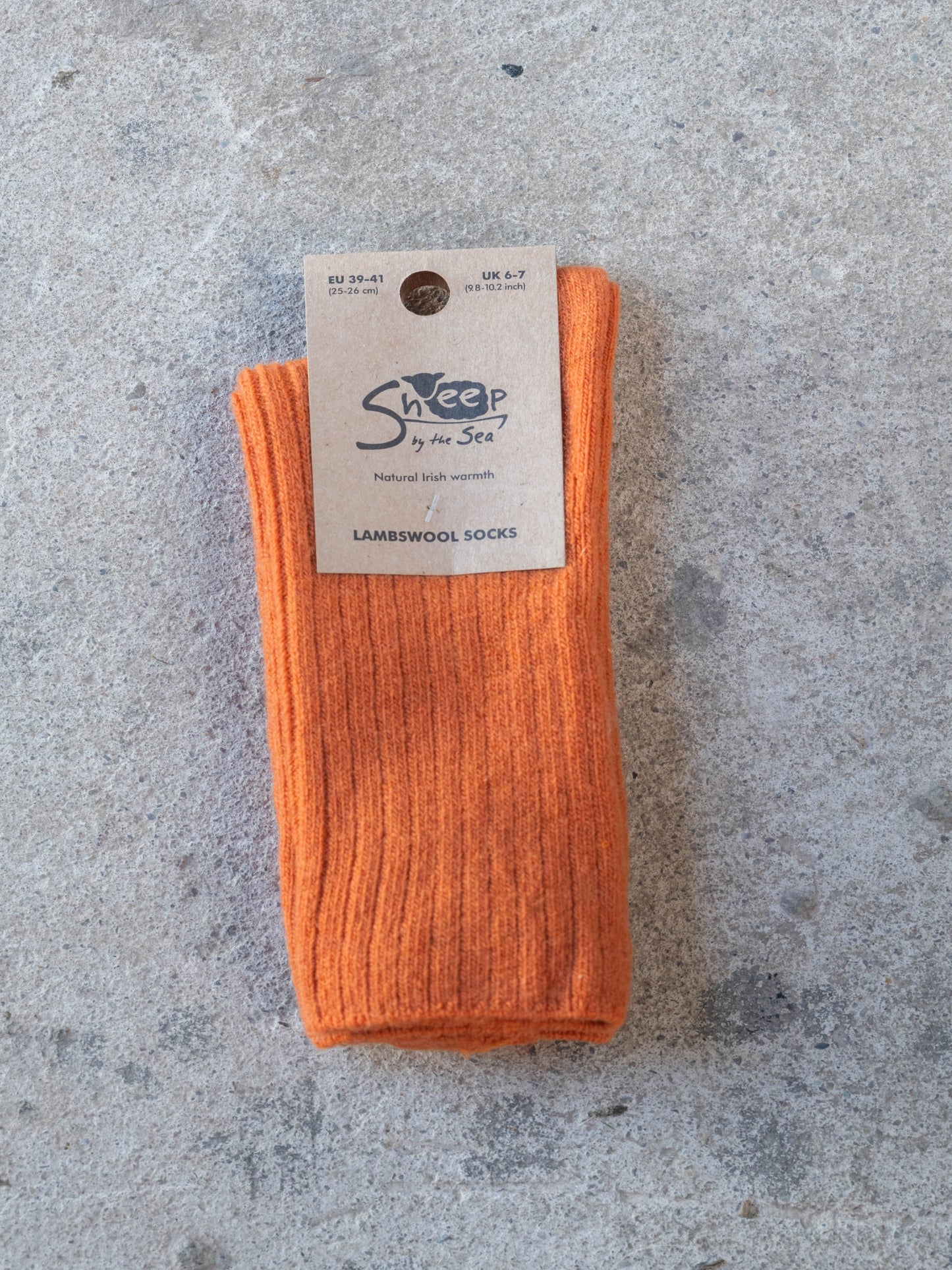 Orange sock with a label on a gray surface