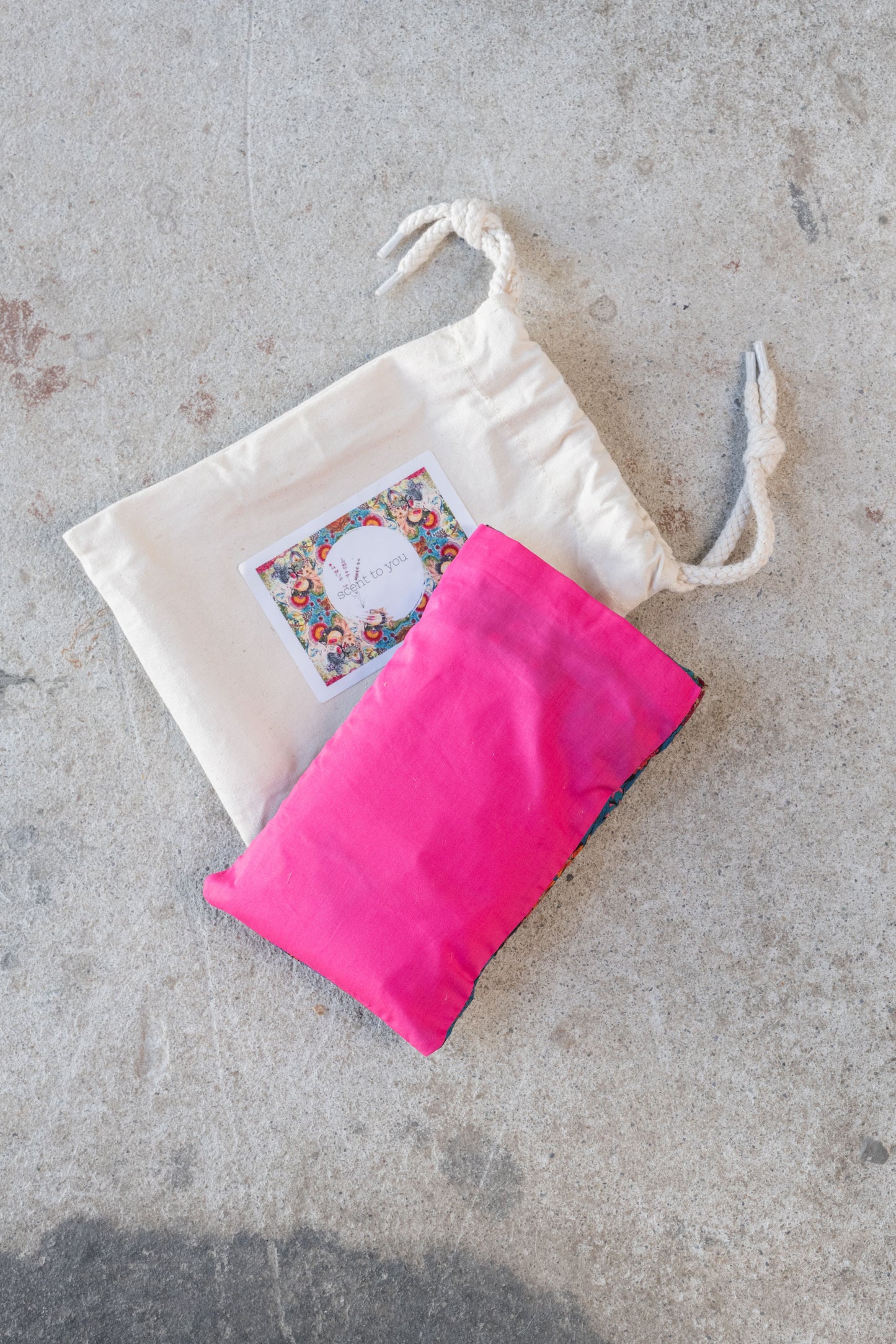 Pink eye pillow on a textured background.