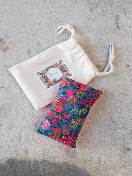 Floral eye pillow and card on a textured surface