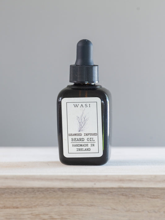 Black bottle of WASI beard oil with a dropper on a white surface.