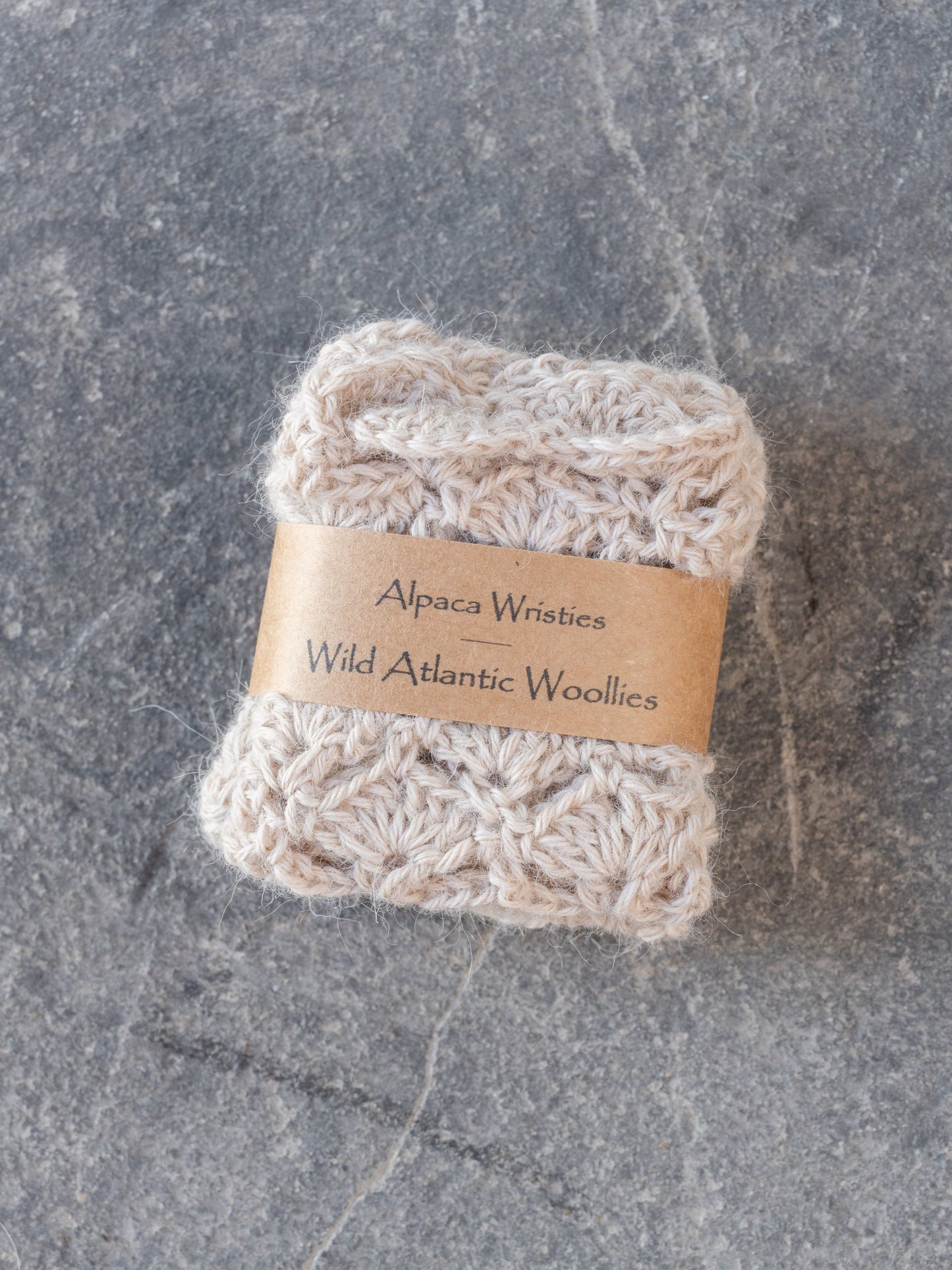 Alpaca wristies with a label on a gray surface