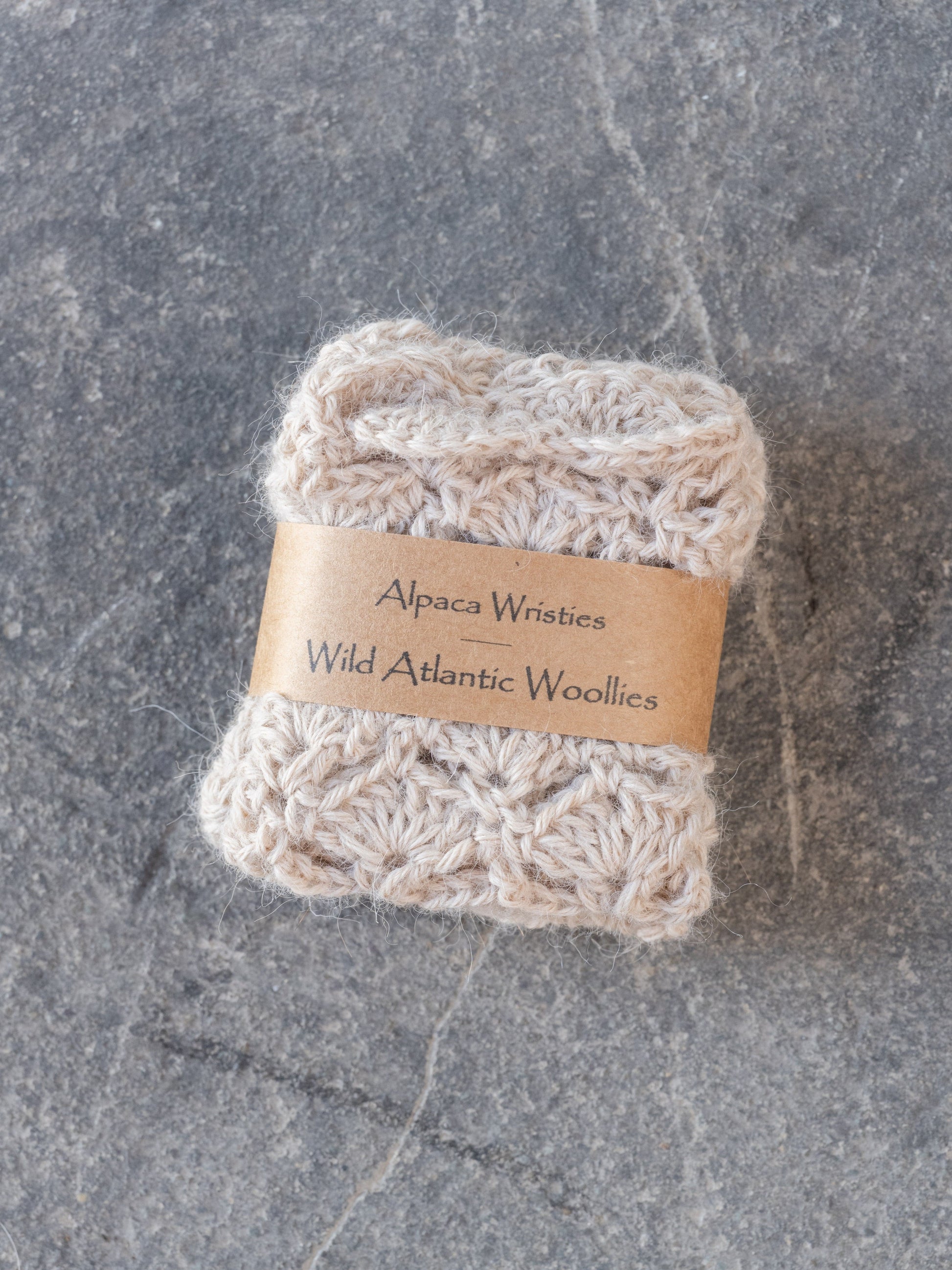 Alpaca wristies with a label on a gray surface