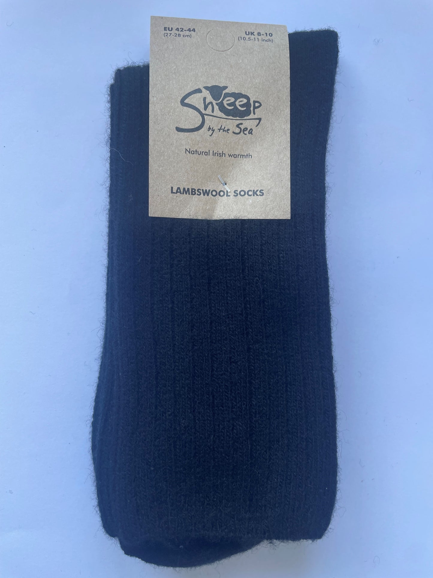 black socks with a brown label that says sheep by the sea, natural Irish warmth, lambs wool socks. 