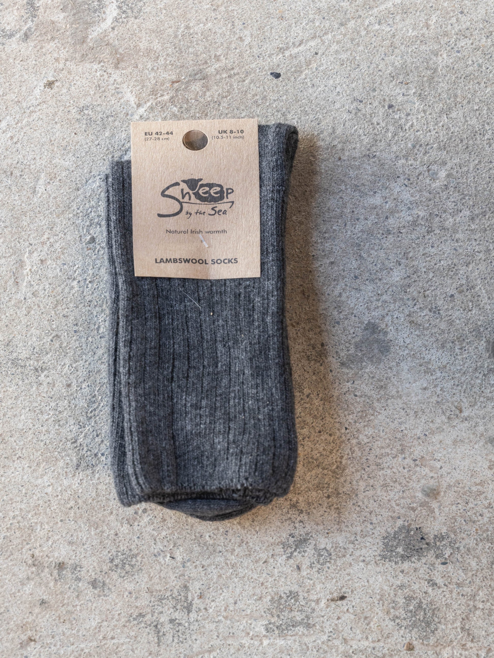 Pair of gray socks with a visible brand label on a textured surface