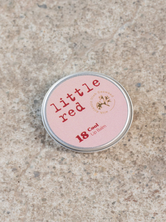 Tin of lip balm with a red label and the words little red on it.