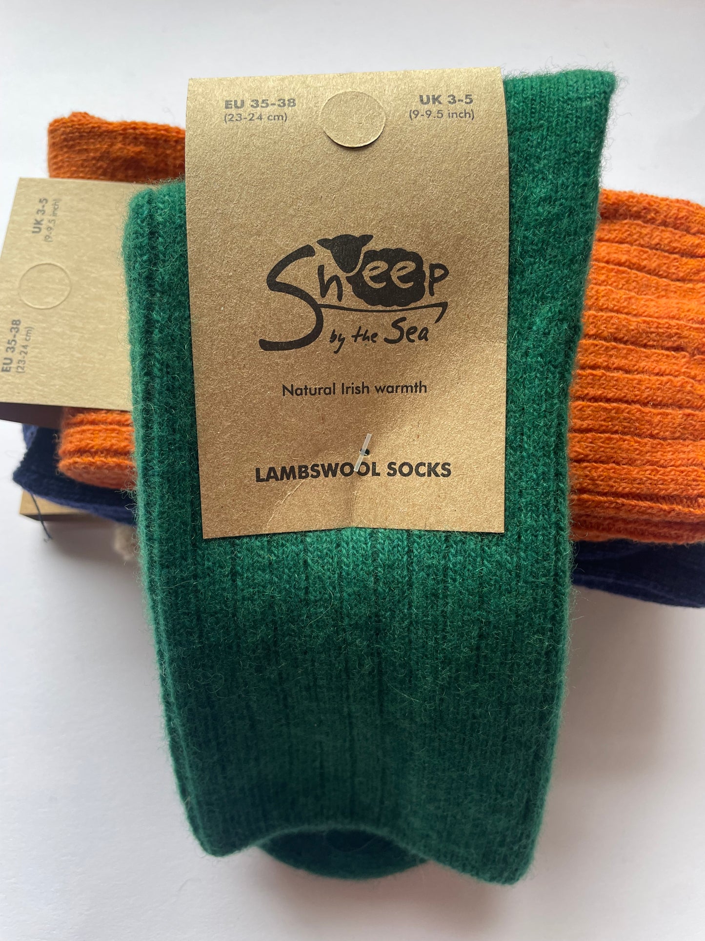 green socks with a brown label that says sheep by the sea, natural Irish warmth, lambs wool socks. 