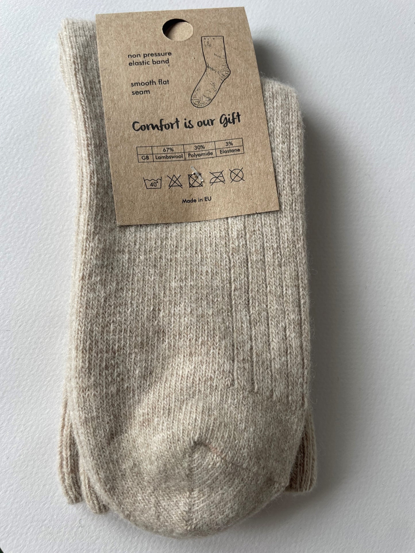 oatmeal socks with a brown label that says sheep by the sea, natural Irish warmth, lambs wool socks. Comfort is our gift. 